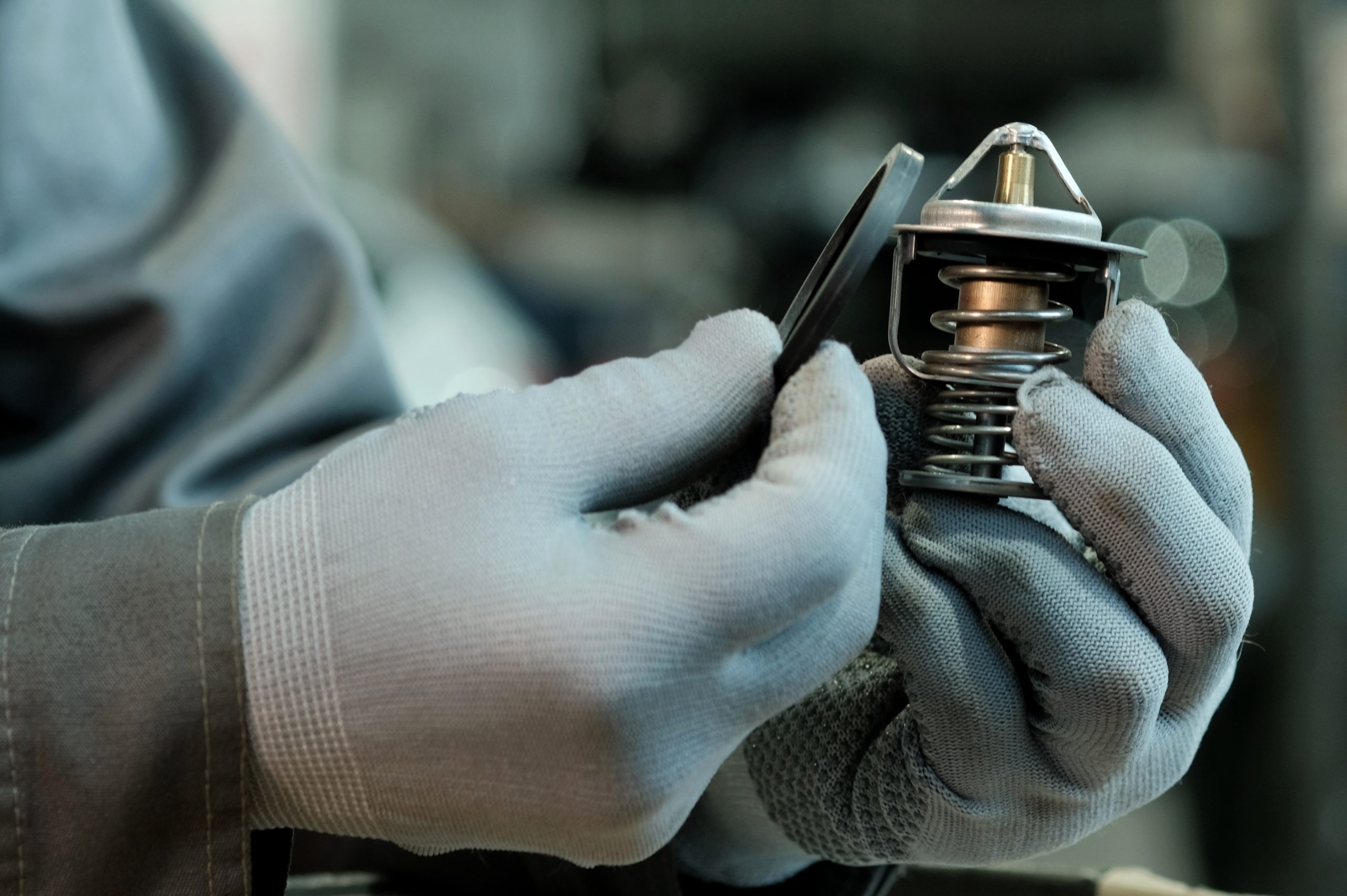 Close up of a water pumpthermostat housing unit showing the plastic housing